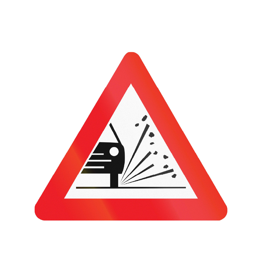 Triangular road sign with a bold red border that depicts a car and rocks flying from the rear wheel.