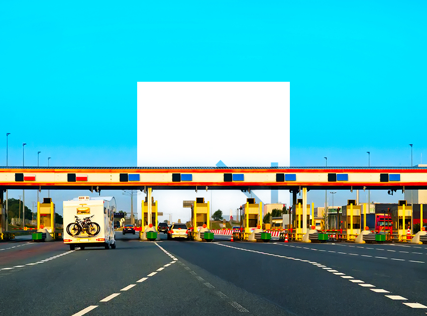 Highway toll plaza under a bright blue sky with multiple lanes.